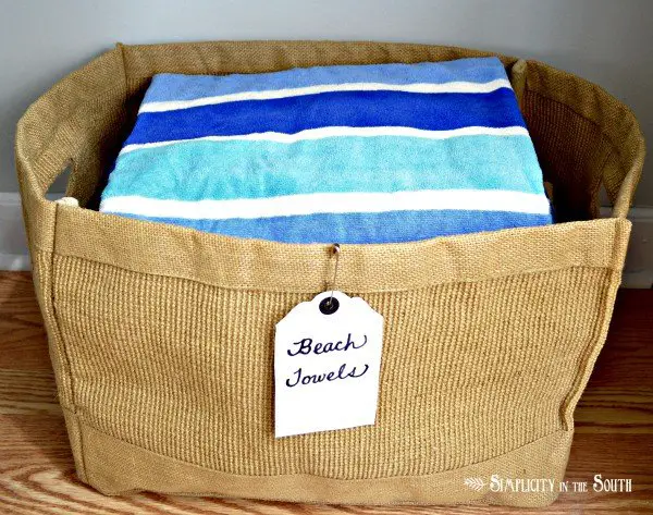 Linen closet organization by Simplicity In The South. Beach towel jute bin.