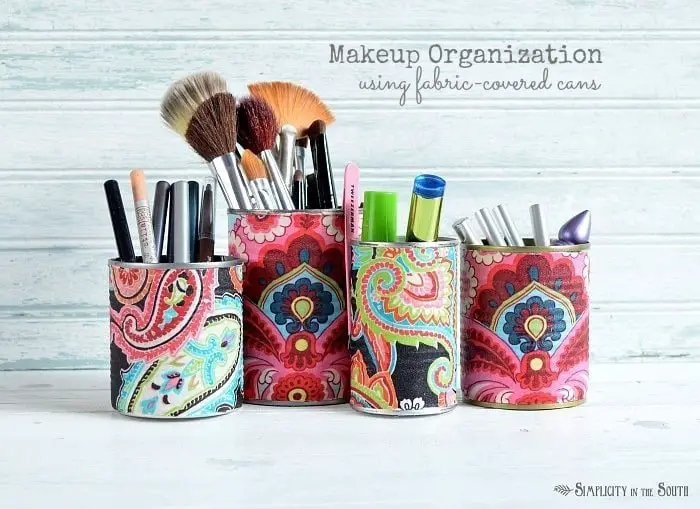 Use fabric covered tin cans to organize makeup and brushes.