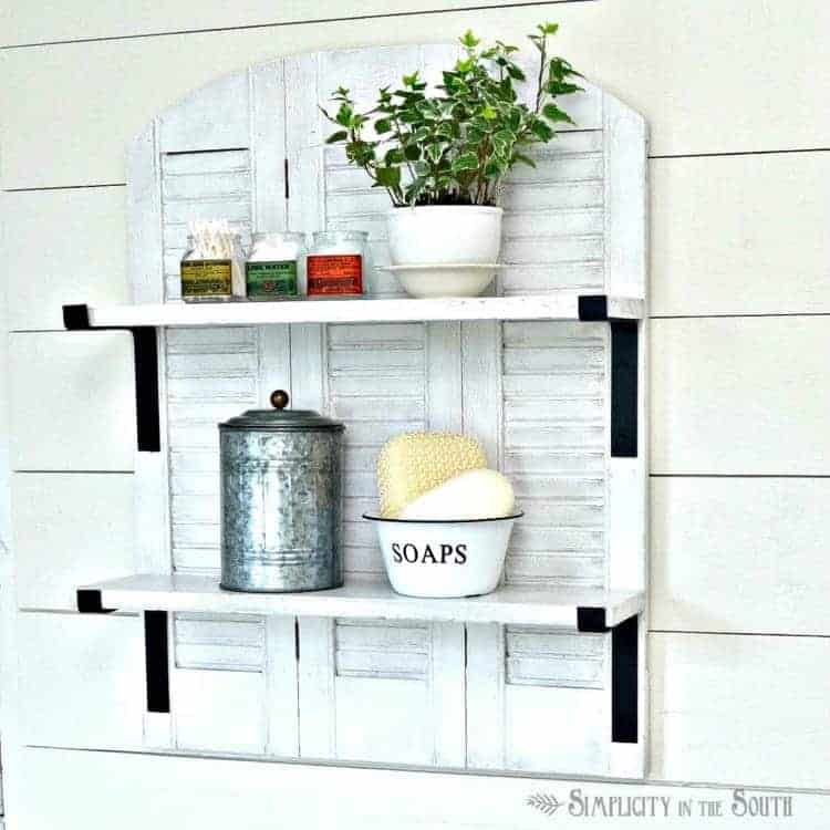 Need some over the toilet storage ideas? In this DIY project, shutters were repurposed into a farmhouse style shelf for the bathroom. This is one of my favorite Ballard Designs knock offs!
