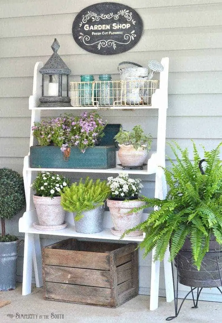 Plant shelf with potted flowers: Need some ideas for decorating your front porch? By adding a repurposed bookshelf from inside the house, you can add plants, flowers, and even candles to welcome your guests.