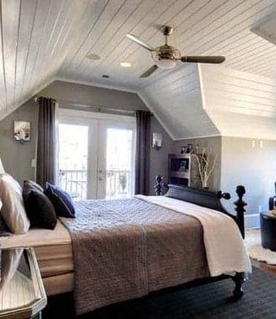 Attic bedroom with planked ceilings and medium gray paint
