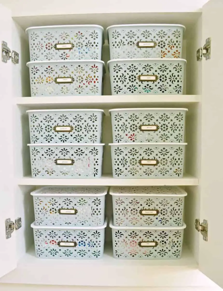 organization idea for bathroom cabinet using stacked lidded bins with labels
