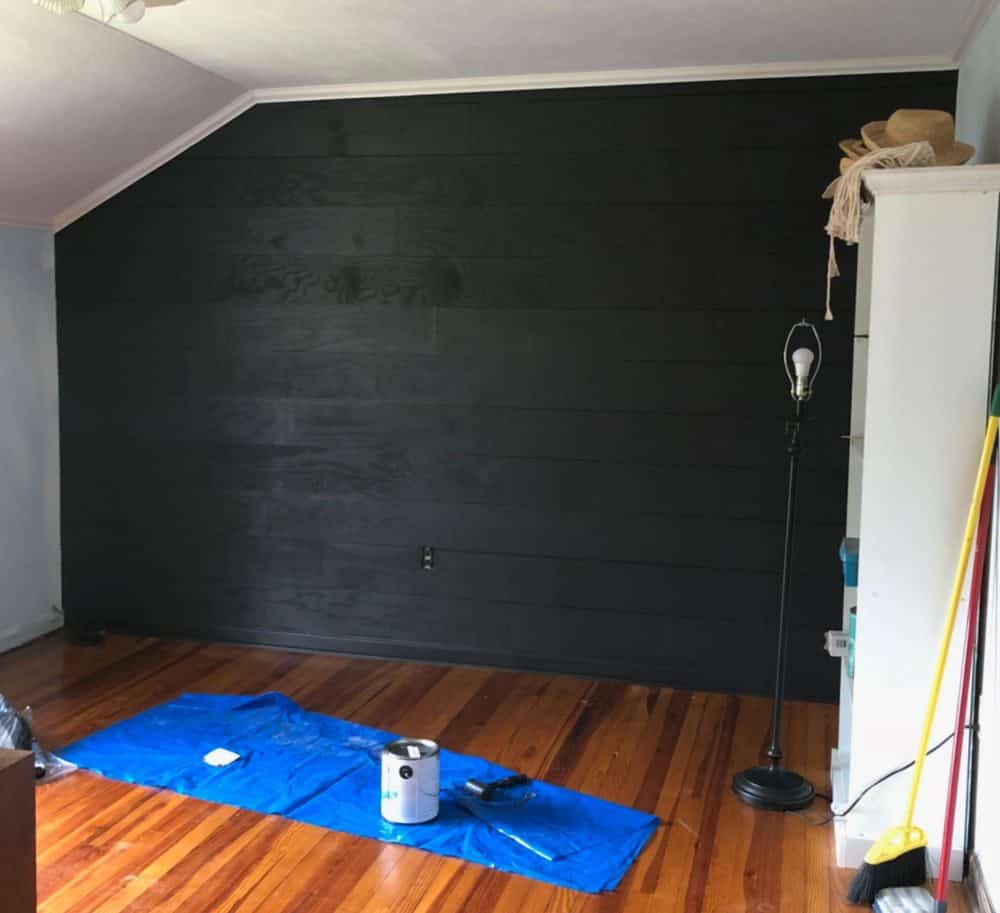 bedroom in progress with black shiplap walls